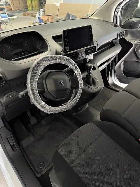 Habitacle Peugeot Partner nettoyé avec volant protégé après detailing Presticar